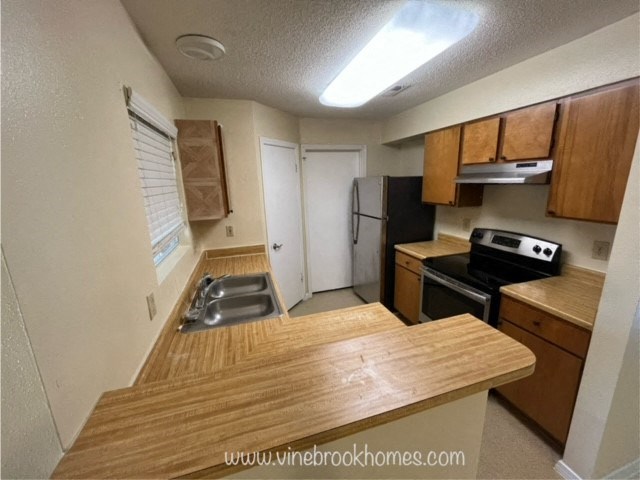 a kitchen with a wooden counter top and a sink