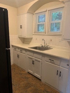 a white kitchen with a sink and white cabinets