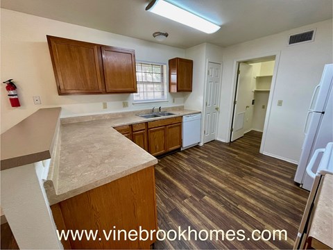 A kitchen with wooden cabinets and a marble countertop.