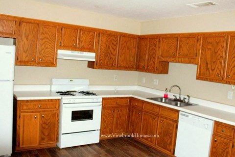 A kitchen with wooden cabinets and white appliances.