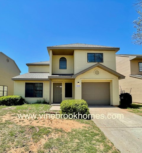 A two-story house with a garage is for sale.