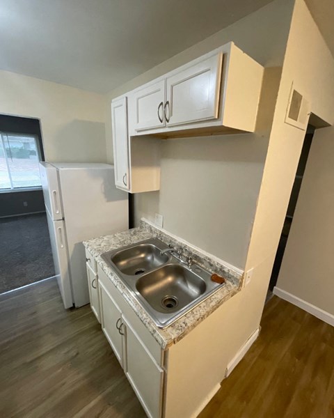 a kitchen with white cabinets and a stainless steel sink