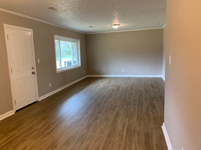 an empty living room with a wooden floor and a white door