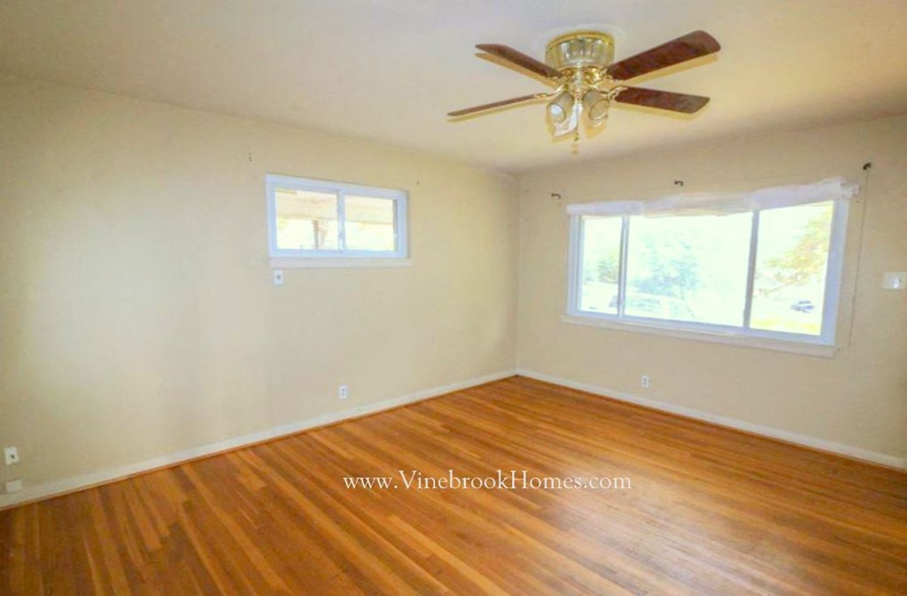 a living room with wood floors and a ceiling fan