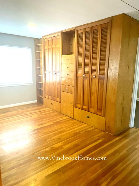 a closet in a living room with wooden floors and