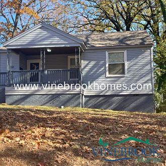 a blue house with a deck on a hill