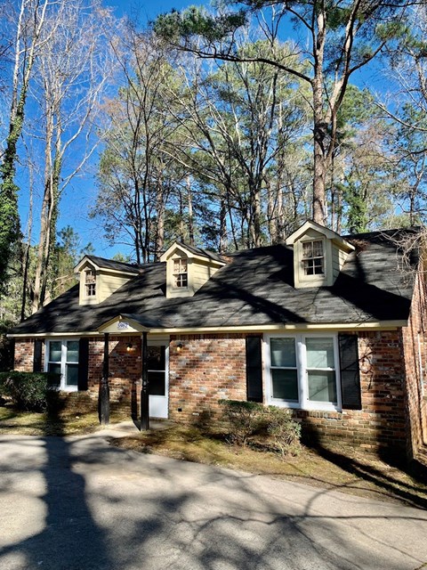 the front of a brick house in the woods