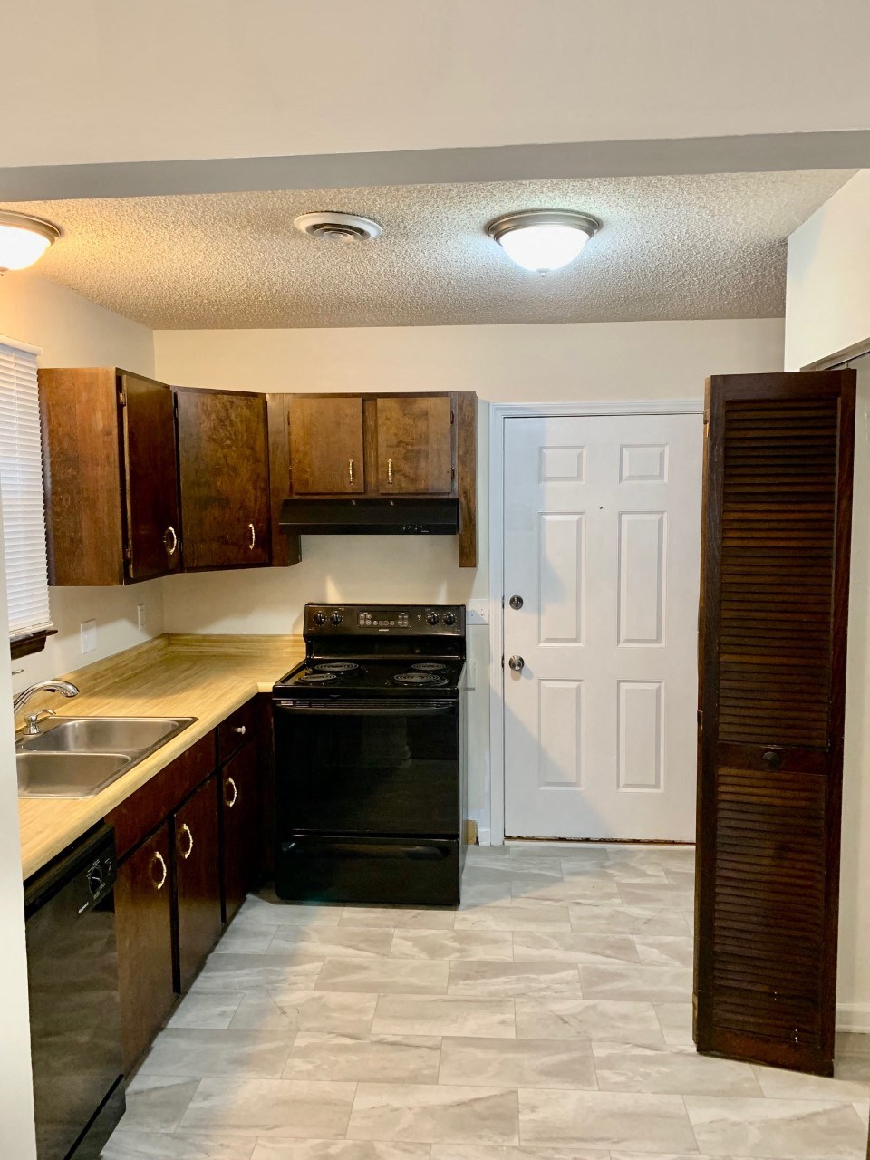 a kitchen with black appliances and wooden cabinets