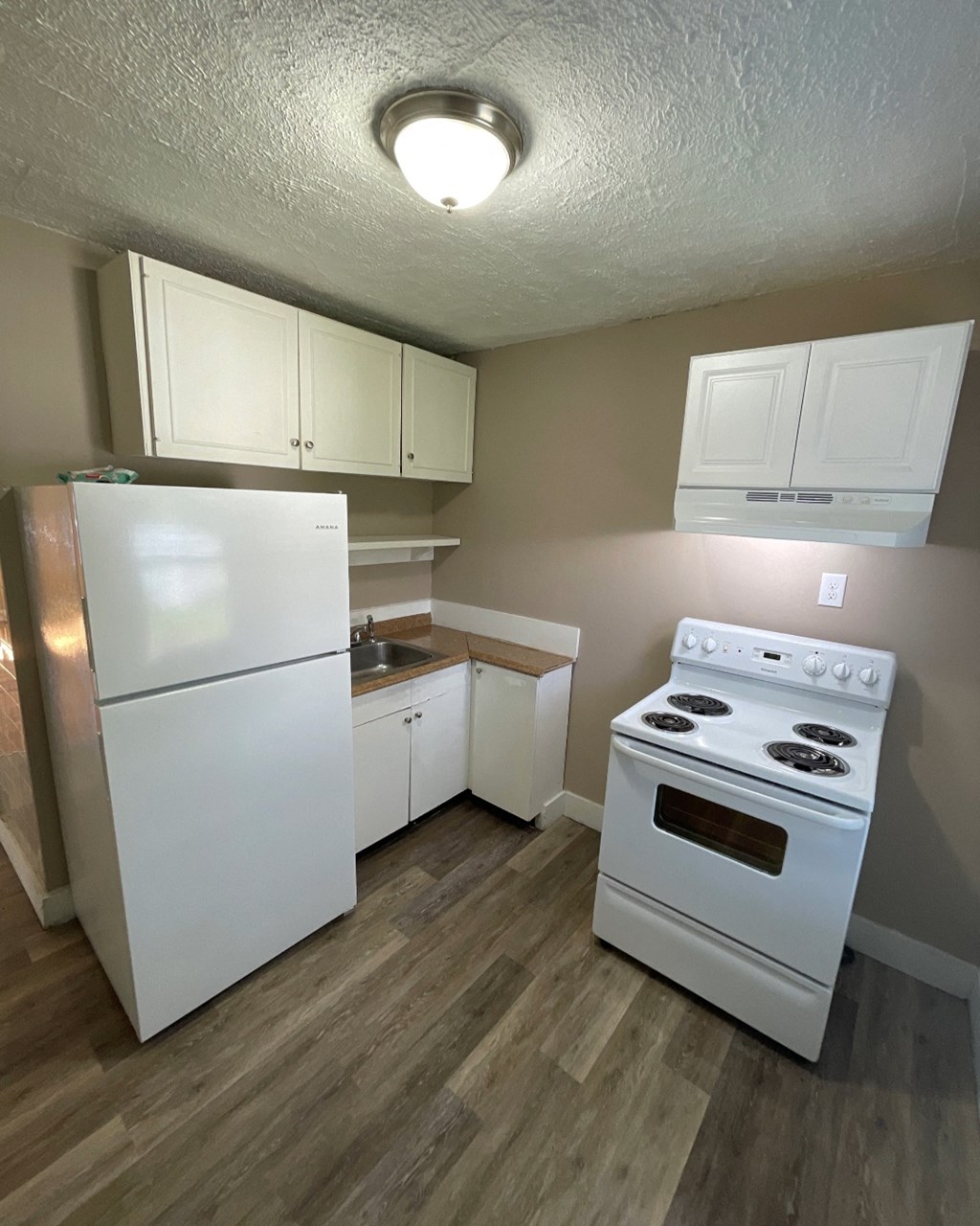 a kitchen with white appliances and a refrigerator and a stove