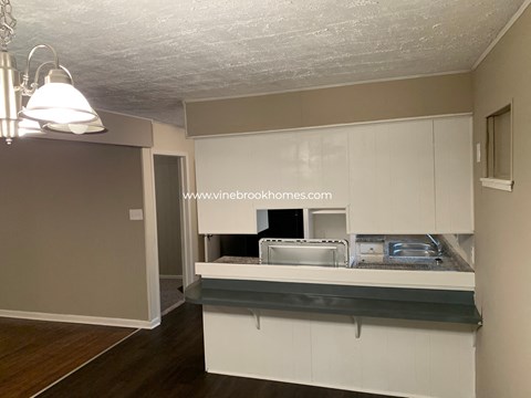 A kitchen with a white counter and cabinets.