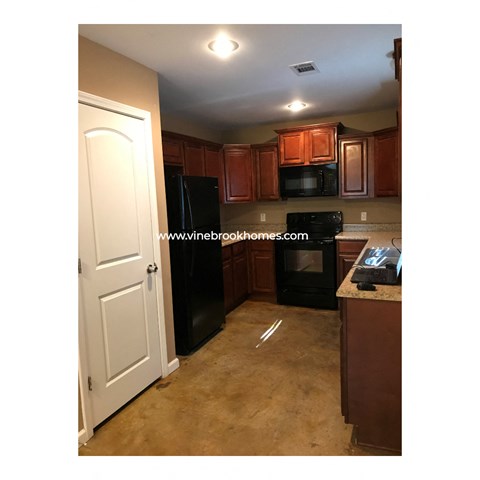 a small kitchen with black appliances and wood cabinets
