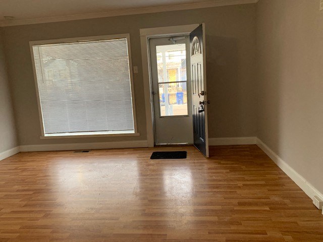 a living room with a hard wood floor and a door