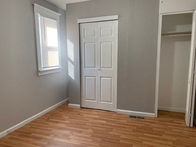 an empty room with a white door and a wooden floor