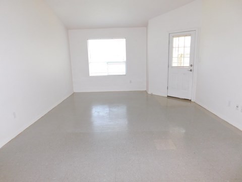 an empty room with white walls and a window and a door