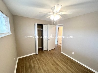 a bedroom with a closet and a ceiling fan