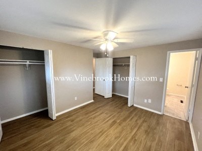 a large bedroom with a closet and a ceiling fan