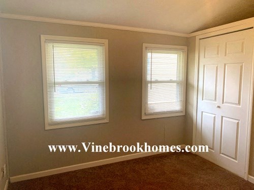 a living room with two windows and a white door