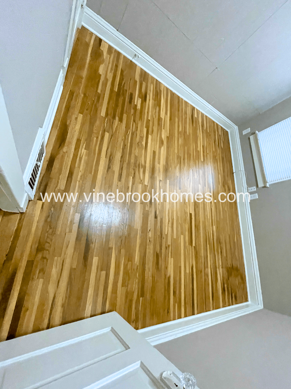 the living room has hardwood floors and a sliding glass door