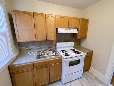 a kitchen with wooden cabinets and a white stove