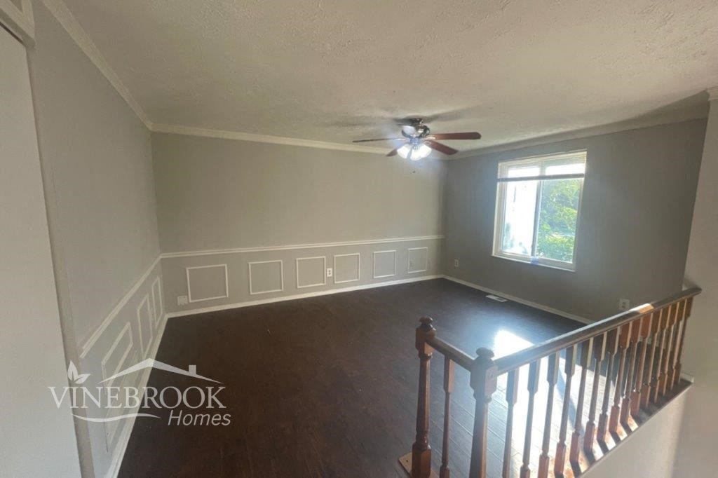 a living room with a staircase and a ceiling fan