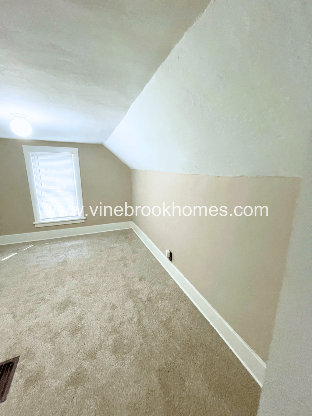 a bedroom with a carpeted floor and a window