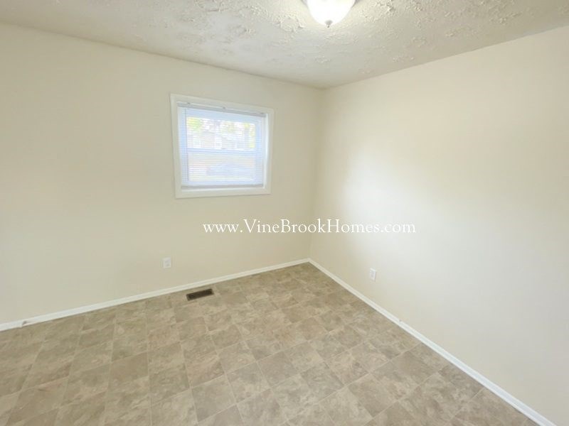 an empty room with white walls and a window