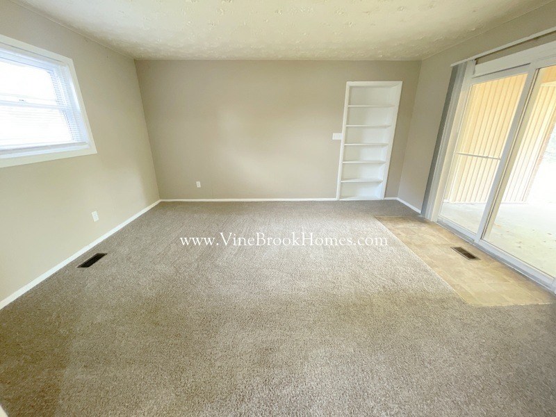 a bedroom with a carpeted floor and a closet and a window