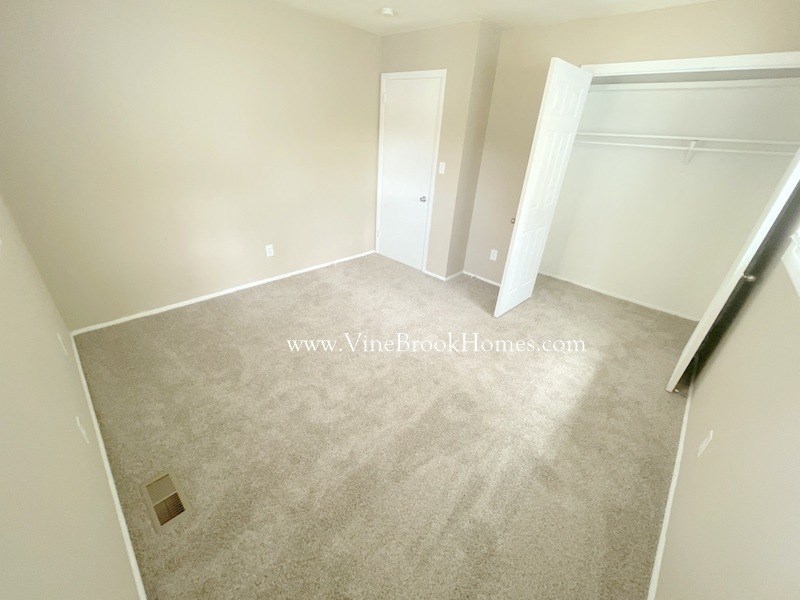 a bedroom with a carpeted floor and a closet