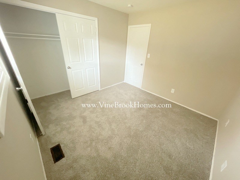 a bedroom with a carpeted floor and a closet