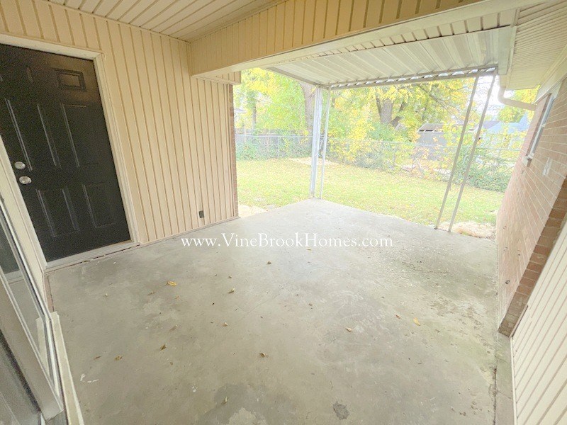 a covered porch with a door to a screened in porch