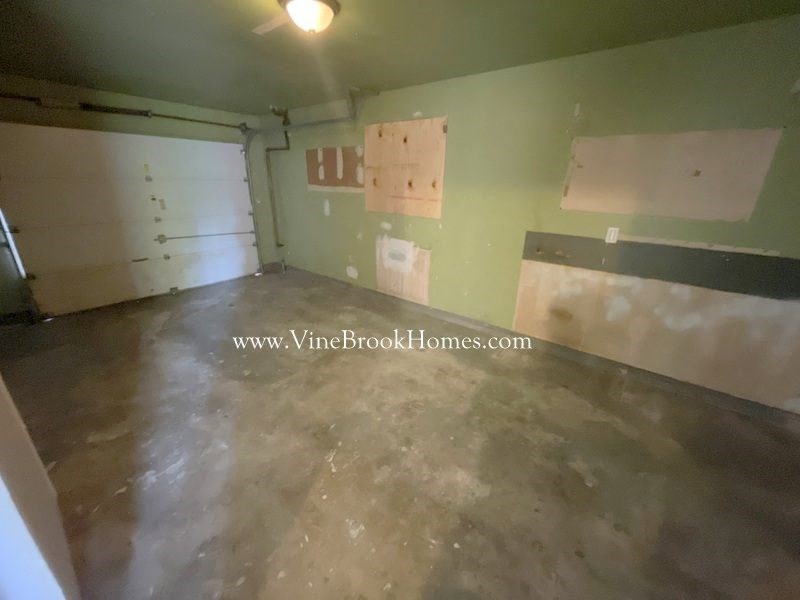 a room with a concrete floor and green walls and a white door