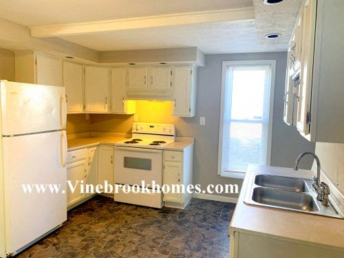 a kitchen with white appliances and white cabinets