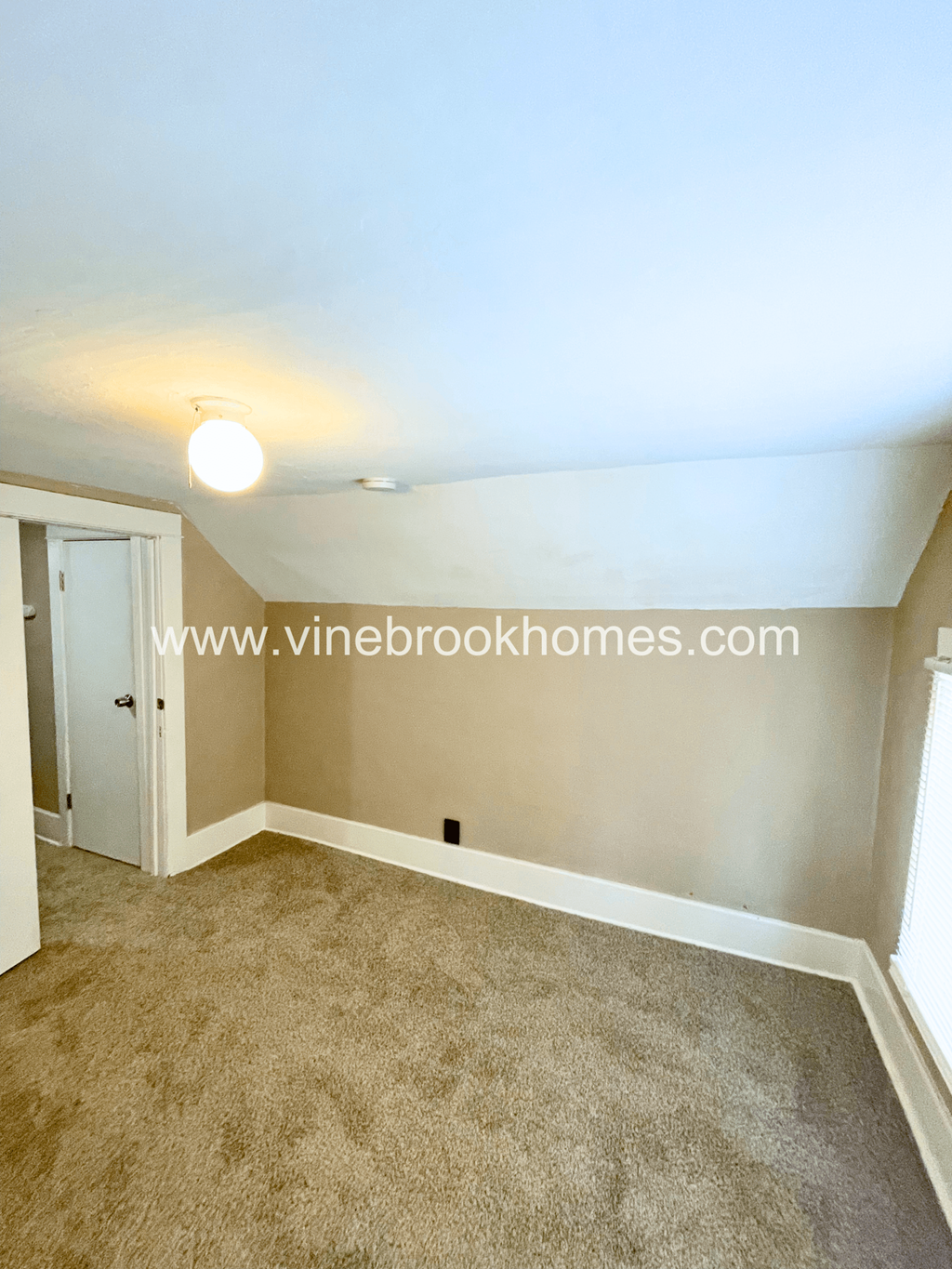 a small bedroom with a carpeted floor and a door to a closet