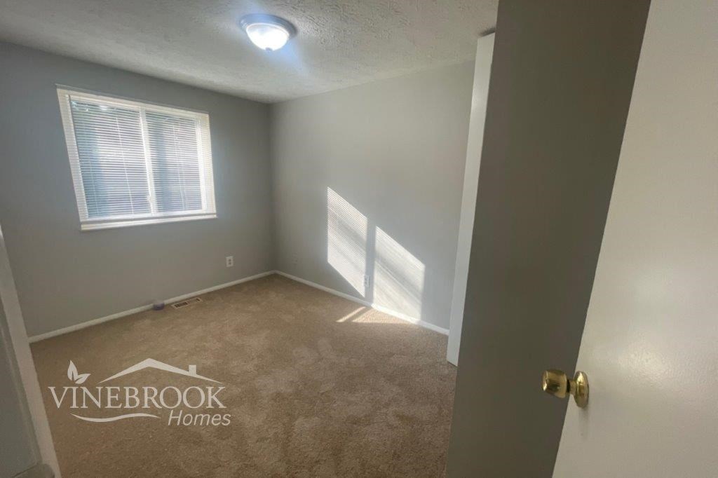 a room with a carpeted floor and a window