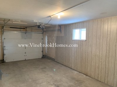 a small room with a garage door and a window
