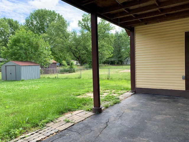 a porch of a house with a yard and a fence