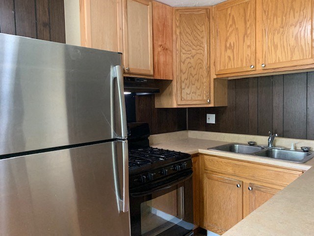 a kitchen with a stainless steel refrigerator and a sink