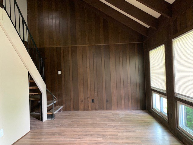 a living room with wooden walls and a staircase