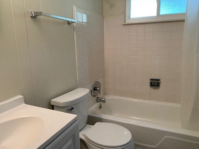 a bathroom with a toilet and a tub and a sink