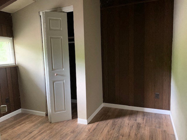 an empty room with a white door and wood floors