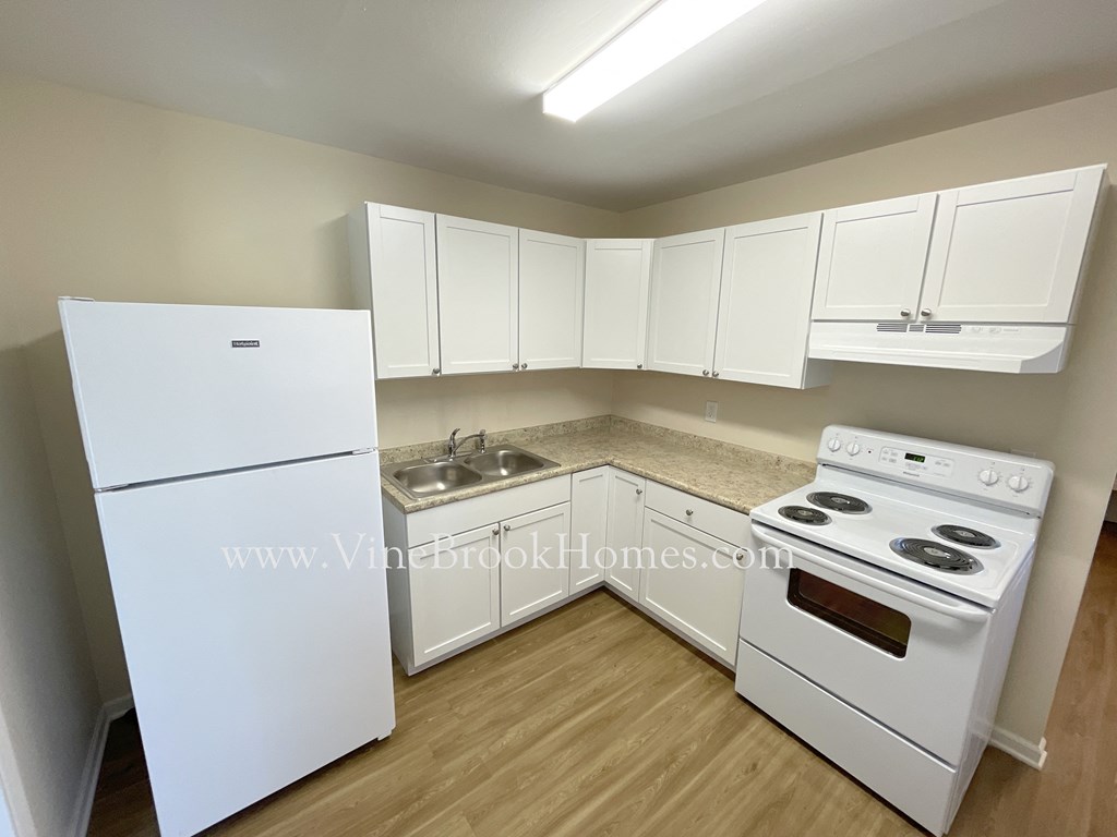 a kitchen with white appliances and white cabinets