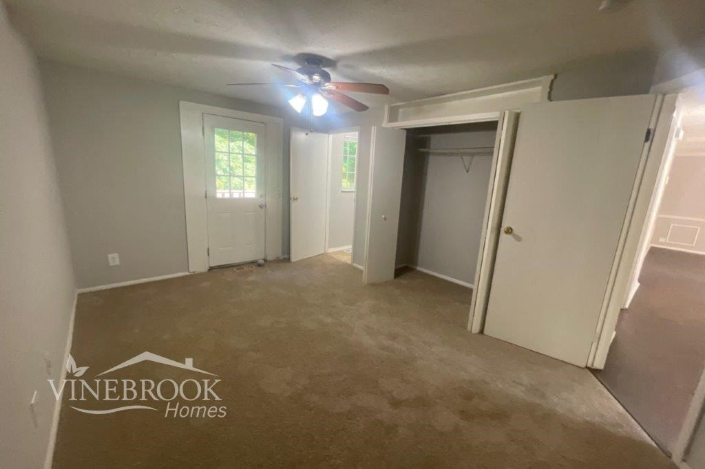 a empty room with a ceiling fan and a closet