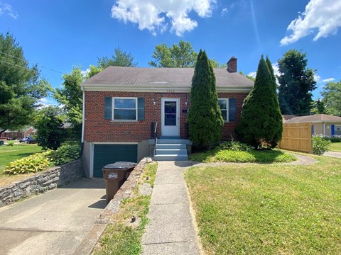 the front of a brick house with a sidewalk in front of it