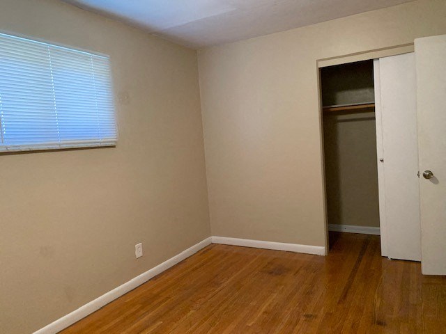 an empty room with a closet and a window