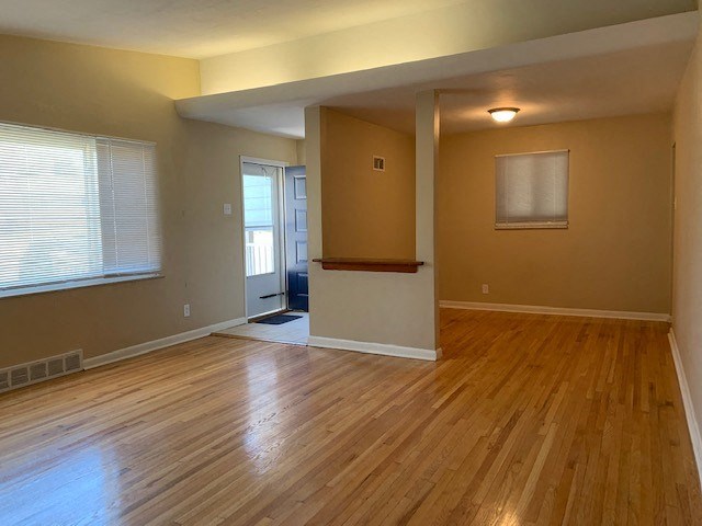 an empty living room with a hard wood floor