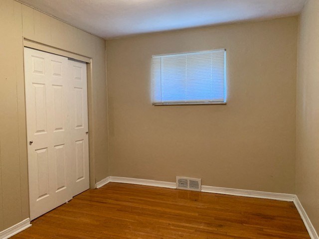 an empty room with a white door and a window