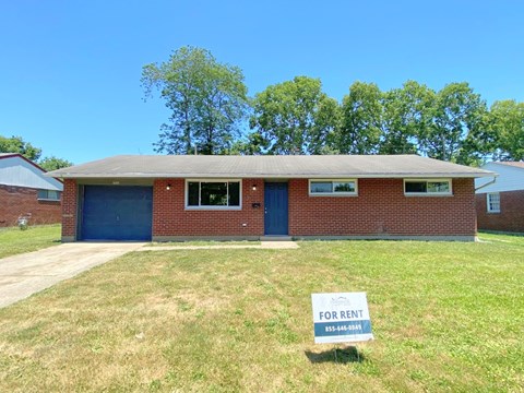 a brick house with afor rent sign in front of it