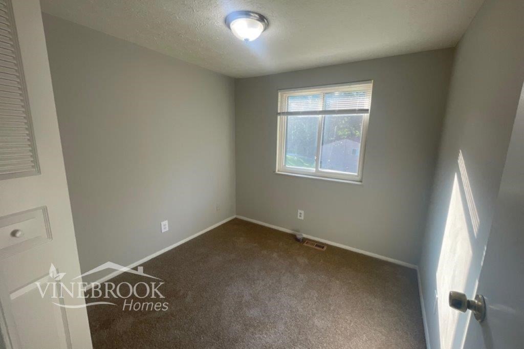 a small room with a window and a carpet