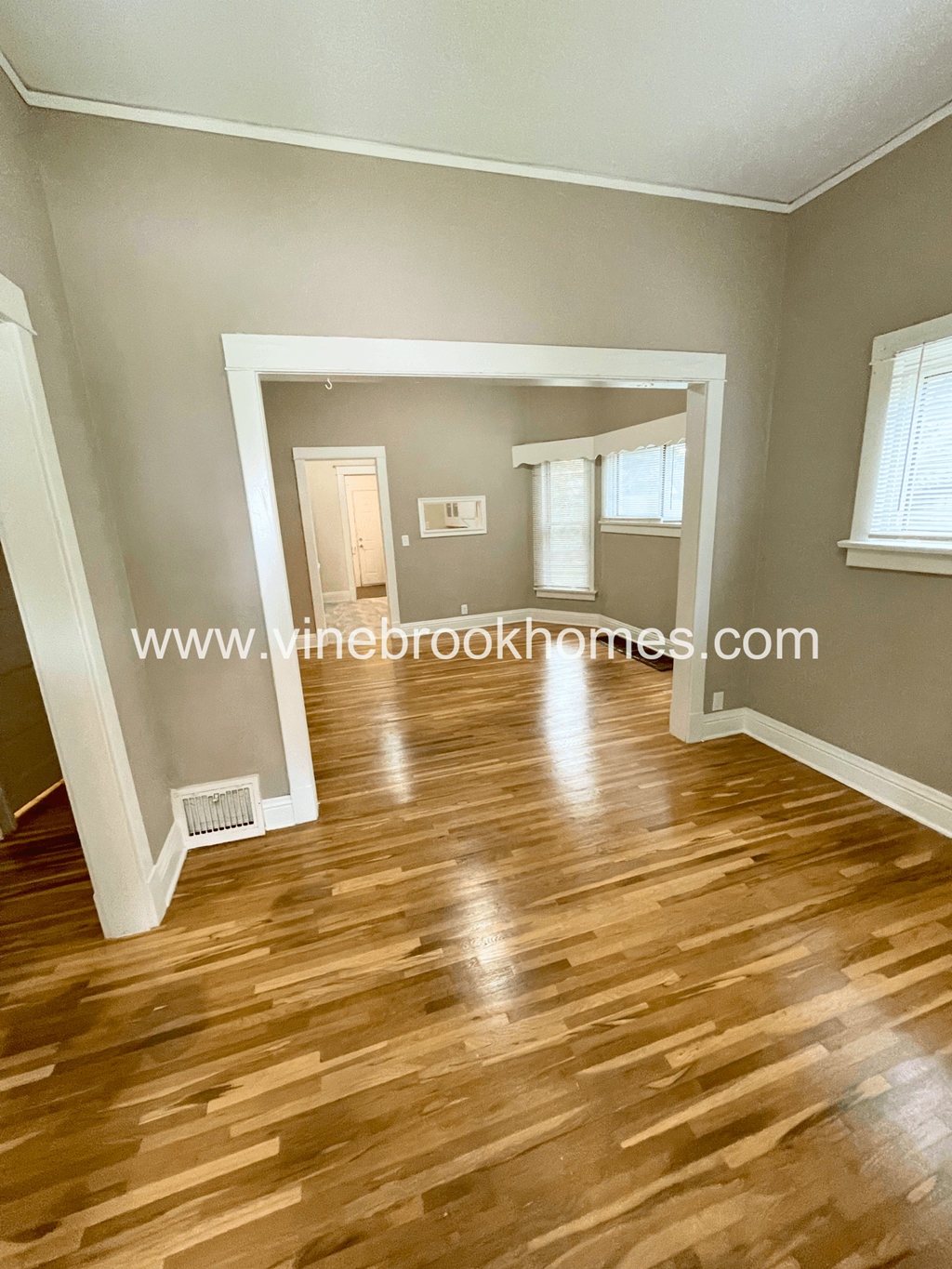 a view of the living room from the dining room and the entrance to the kitchen