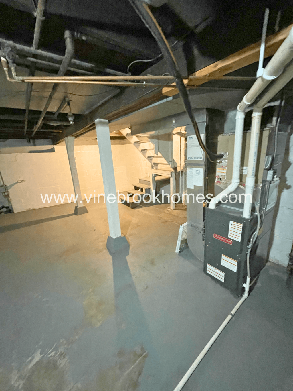 a large basement with a boiler and pipes in it